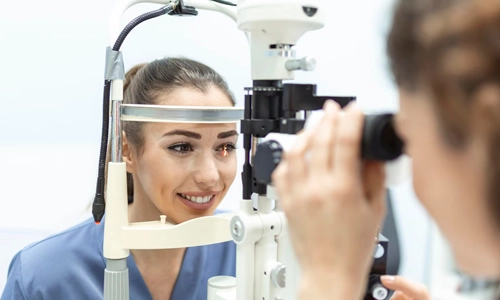 An ophthalmologist using specialized medical equipment to perform an eye exam on a female patient