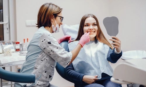 A woman sitting in a dental chair for a routine twice-yearly dental check-up and teeth cleaning