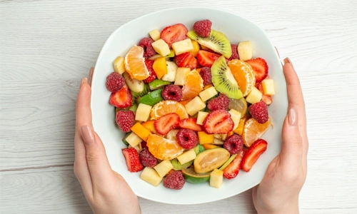 Top view delicious fruit salad sliced fruits inside plate on a white color healthy life photo fruit mellow ripe