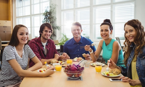 Group of young adults enjoying a healthy meal together at a dining table
