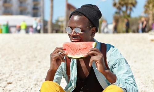 Young man enjoying watermelon on a sunny day