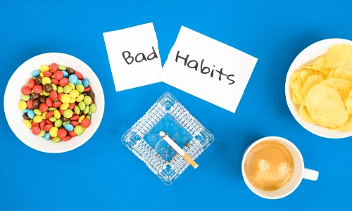 Top view of common bad habits including smoking, sugary snacks, coffee consumption, and potato chips.