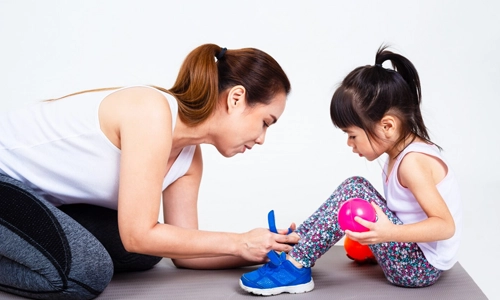 Mother helping her daughter get ready for sports practice