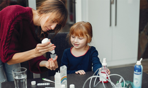 Child happily taking flavored bubblegum medicine from a parent