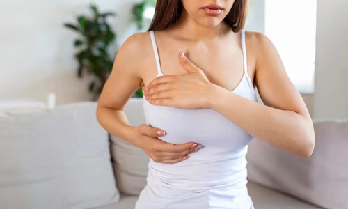 Woman checking her breast during a self-exam for early breast cancer detection