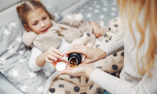 Parent calmly giving medicine as part of daily routine