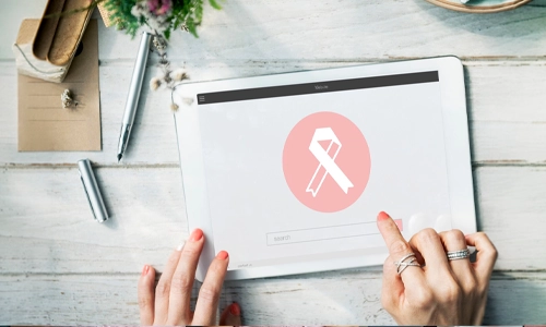 Person browsing breast cancer awareness information on a tablet displaying a pink ribbon symbol