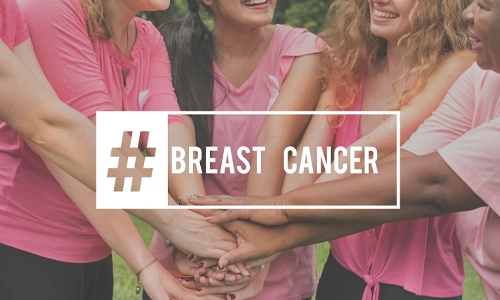 Women wearing pink shirts joining hands to show support for breast cancer awareness and community solidarity