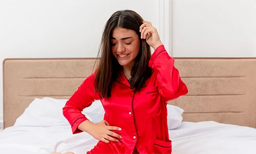 Young woman in red pajamas, symbolizing early pregnancy fatigue and missed period signs.
