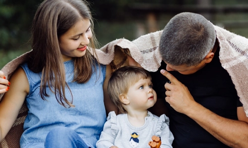 Happy family spending time together outdoors, representing the successful path to parenthood through adoption.