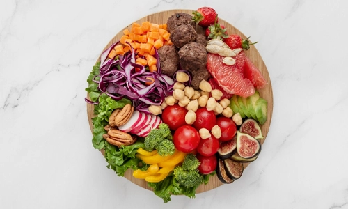 This image displays a flexitarian diet food arrangement, which features a variety of plant-based foods alongside a moderate amount of meat.