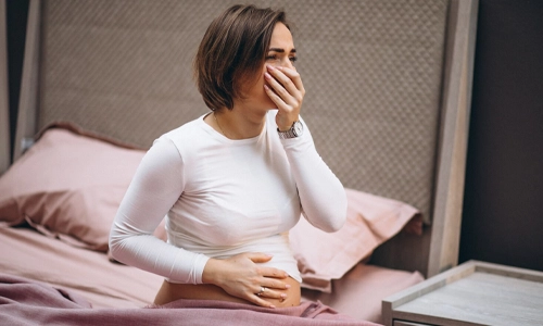 Stressed pregnant woman with her hand on her forehead due to severe pregnancy discomfort.