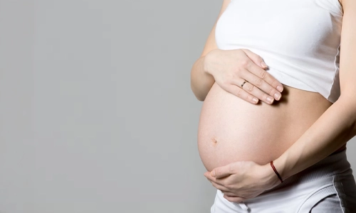 Image of a pregnant woman touching her belly.