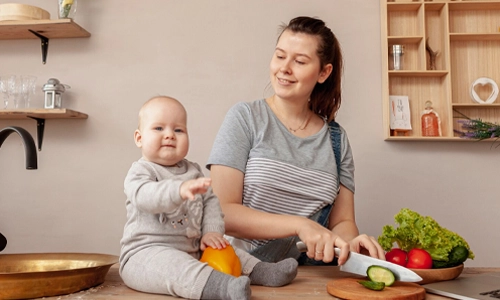 Mother holding her baby at home, representing the balance of self-care and parenting in the early weeks.