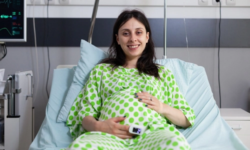 Image of a pregnant woman sitting in a hospital ward bed