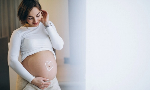Image of a Pregnant woman applying cream on the belly to prevent stretches