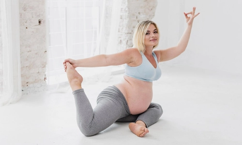 Image of a pregnant woman practicing a seated yoga posture, doing Marichyasana.