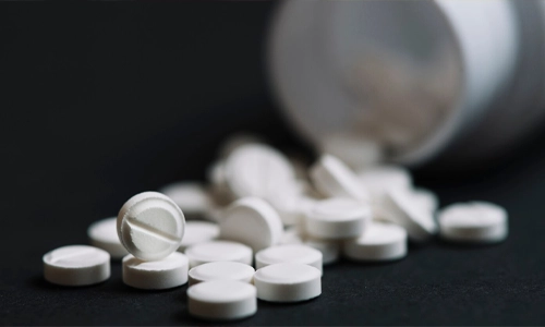 White pills falling out of a prescription bottle