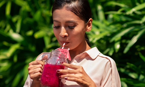 Woman drinking a fresh fruit drink outdoors